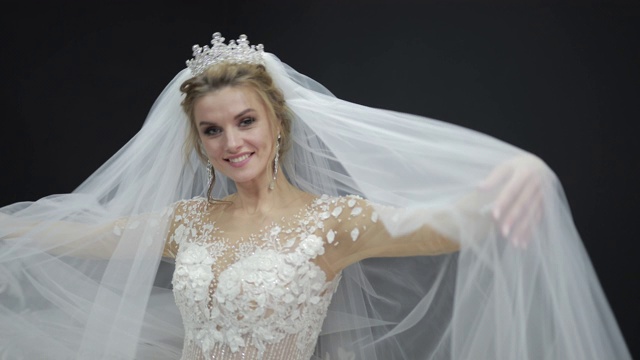 年轻美丽的新娘在白色婚纱玩面纱制造波澜视频下载