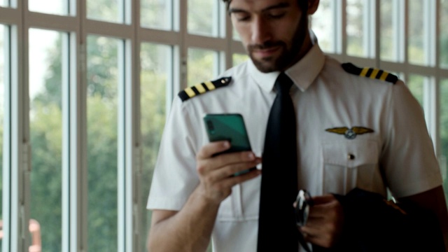 飞行员在机场航站楼使用智能手机视频素材