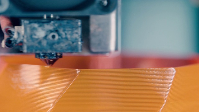 近距离的橙色物体打印在3D快速运动视频素材