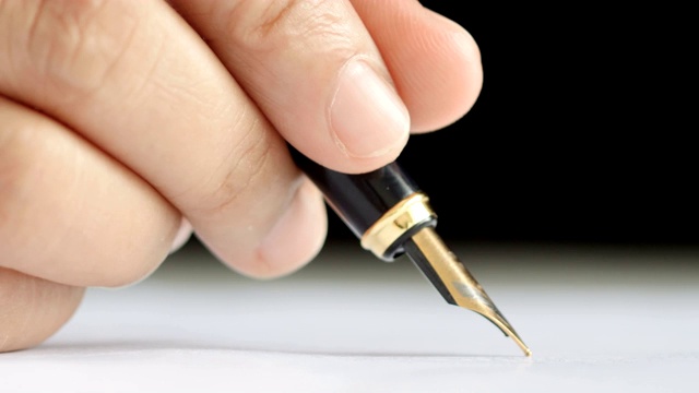 特写镜头女子用笔在纸上写字的手视频素材