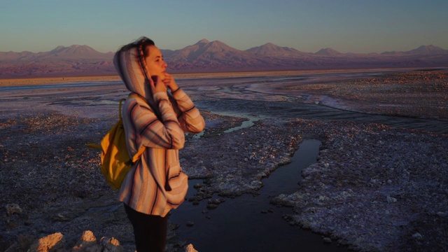 在阿塔卡马沙漠的风景湖的背景上的女人视频素材