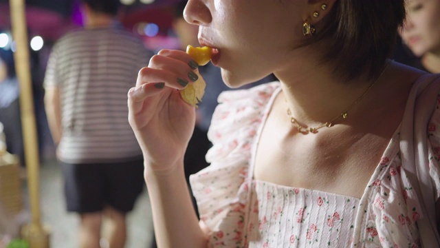 年轻的亚洲女人尝试街头食物，泰国视频素材