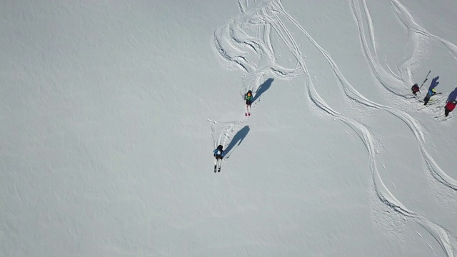无人机拍摄的一名滑雪者从白雪覆盖的山上滑下来，上面覆盖着新鲜的粉末雪。——慢动作视频素材