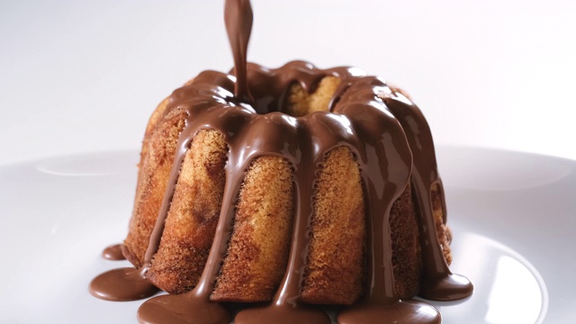将巧克力牛轧糖糖霜倒在大理石蛋糕上视频素材