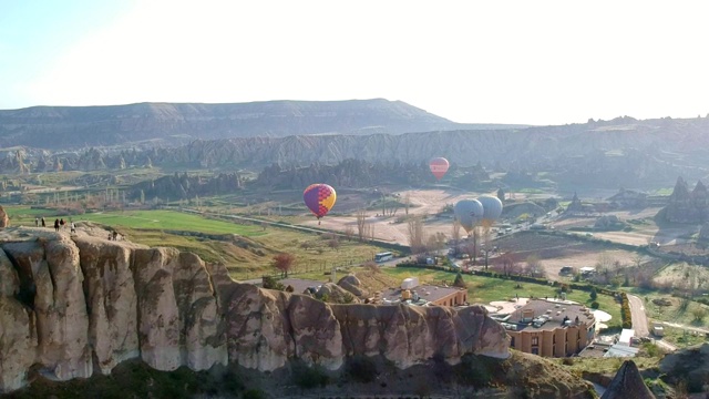 彩色的热气球飞过卡帕多西亚的山谷和真菌状的砂岩，无人机在土耳其卡帕多西亚的火山上拍摄的镜头视频素材
