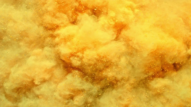 一个充满橙黄色粉末的表面向相机喷射，在近距离和超慢的动作中产生烟熏质感视频下载