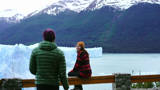 一对夫妇在看风景如画的巴塔哥尼亚莫雷诺冰川视频下载