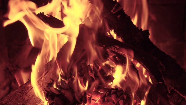 在舒适的砖砌壁炉气氛中，木头慢慢地燃烧着橙色的火焰视频下载