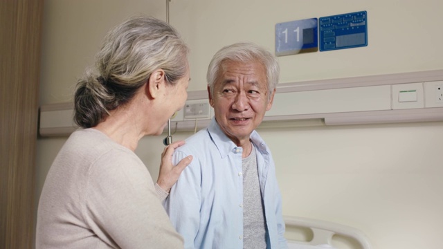 年长的亚洲妇女在医院病房探望丈夫视频素材