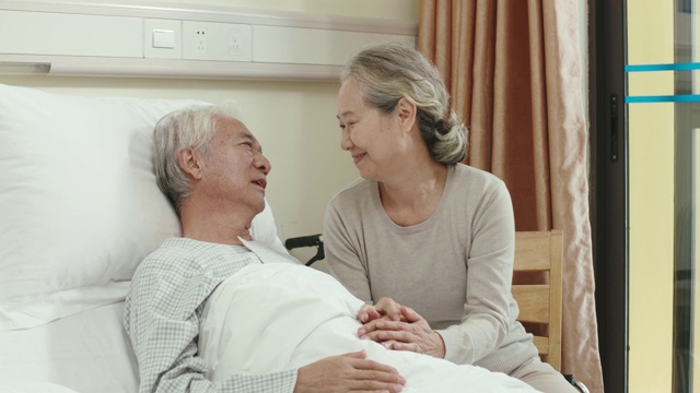 慈爱的亚洲老妇人在医院病房探望丈夫视频素材