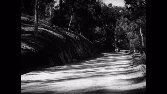 1940年-汽车在道路上行驶的宽镜头视频下载