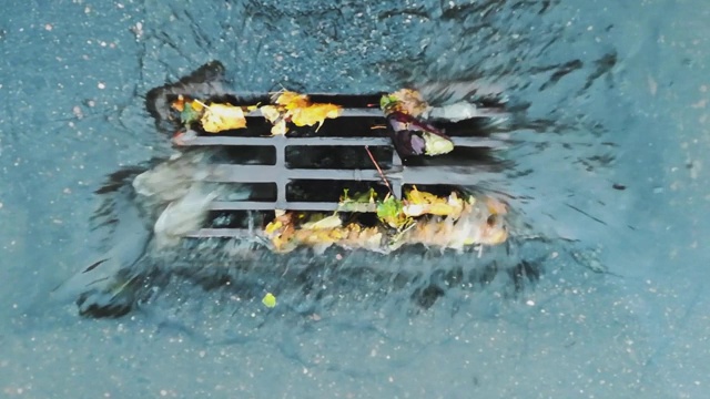 下雨时，水从道路排水沟流入雨水沟下水道收集器。主要渠道的排水网络。城市里的雨天。恶劣和危险的交通条件视频素材