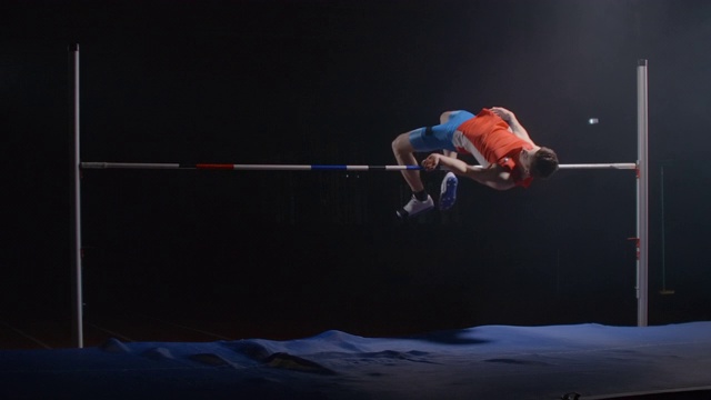 一名男运动员在横杆上跑得和跳得很高。跳高比赛的慢镜头拍摄。成功视频素材