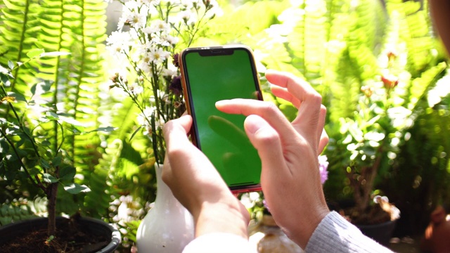 亚洲女性使用绿色屏幕的智能手机视频素材