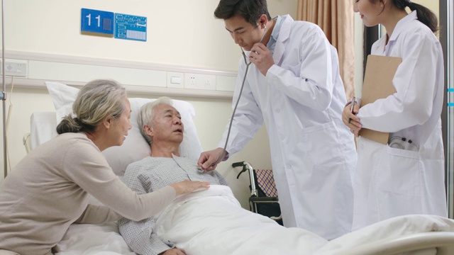 年轻的亚洲医生在医院病房检查老年病人视频素材