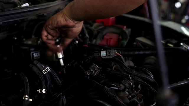 机械师在机械修理厂修理汽车发动机。视频素材