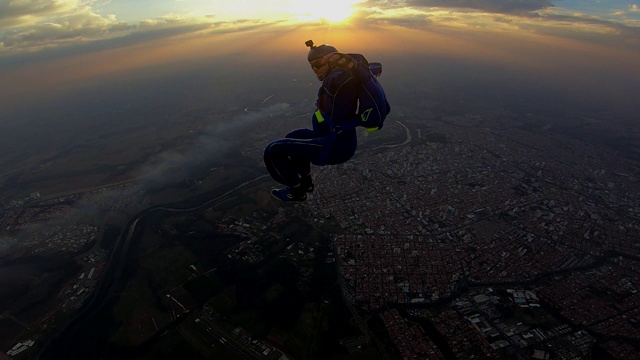 跳伞者在日落时做坐飞姿势视频素材