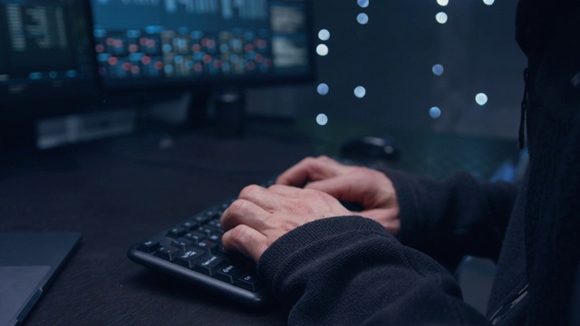 一个男人的手在键盘上打字的特写。在一个暗室里。视频素材