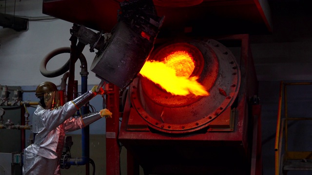 在黄金铸造厂，穿着防护服的工人在熔化黄金视频素材