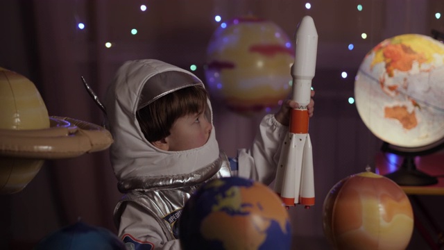 太空旅行游戏灵感飞船。小男孩宇航员从太空港发射玩具火箭穿过行星。梦想家的孩子玩着在行星间飞行的玩具太空火箭。缓慢的运动。视频下载