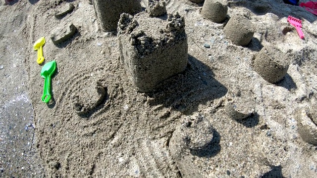 在沙质沙滩蔚蓝的大海南岸建造有塔的沙堡视频素材