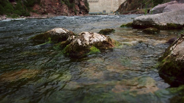 倾斜向上的镜头，绿色的河流在石头上流淌，火焰峡谷大坝在犹他州的背景视频下载