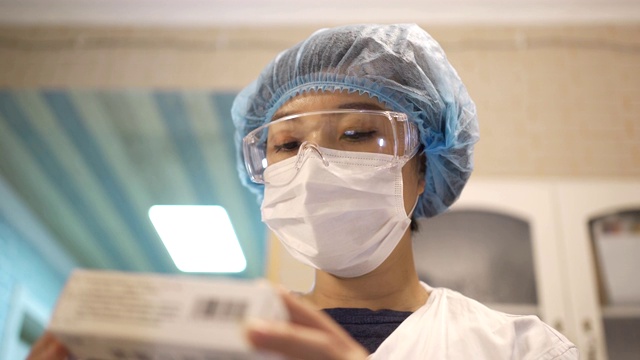 中国女医生戴着口罩和护目镜看药的肖像。视频素材