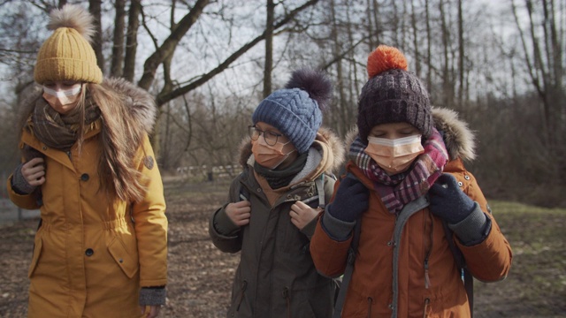 三个孩子戴着防毒面具去上学视频素材