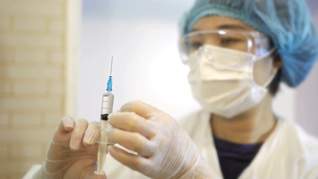 中国女外科医生检查医用注射器。视频下载