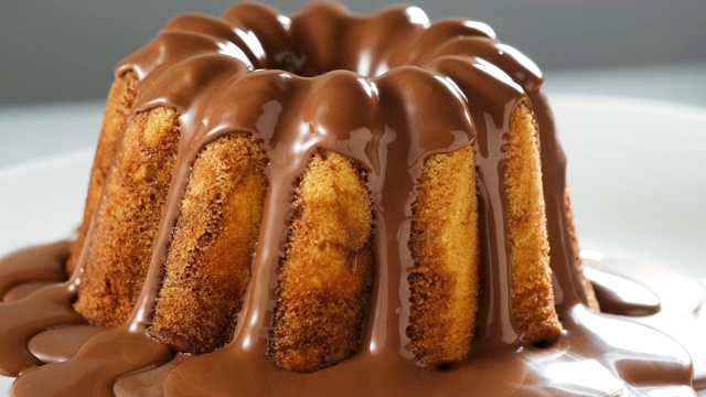 将巧克力牛轧糖糖霜倒在大理石蛋糕上视频下载