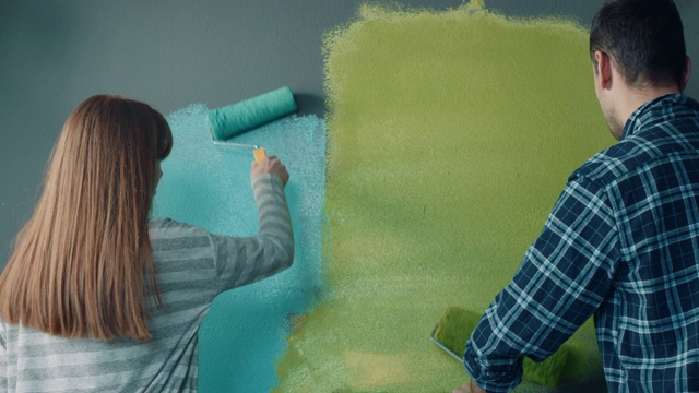 一对夫妇在他们的新房子粉刷墙壁视频素材