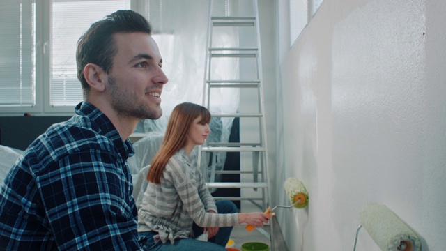 一对夫妇在他们的新房子粉刷墙壁视频素材