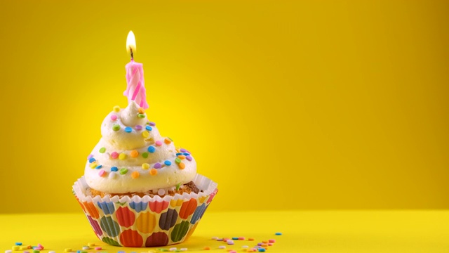 用蜡烛和糖屑装饰的生日蛋糕。蜡烛最后会被吹灭。——滑动镜头视频素材