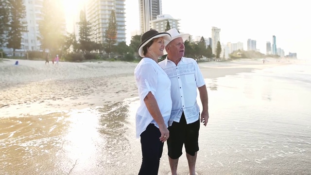 一对幸福的老年夫妇在海滩上散步视频素材