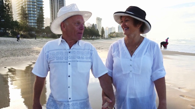 一对幸福的老年夫妇在海滩上散步视频素材