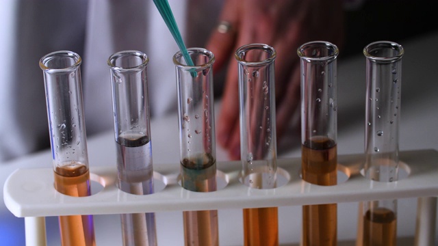 科罗拉多大学女科学家在试管中滴下绿色液体视频素材