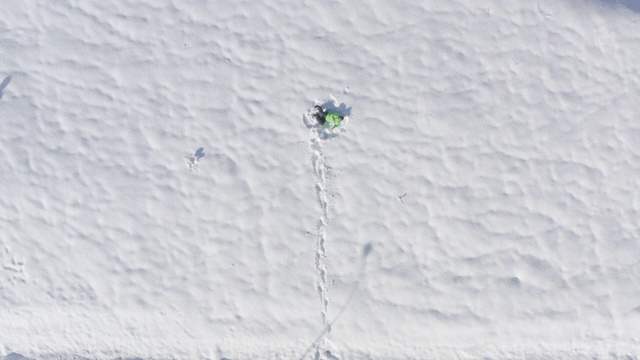在冬季雪堆上行走的人。鸟瞰图上的人在冬天走白色蓬松的雪。快乐的人躺在冬天的雪地上。冬天人们活动视频下载