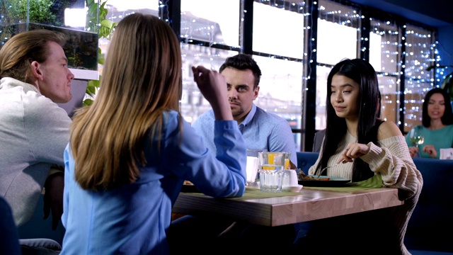 年轻人在餐馆聊天的侧视图视频素材
