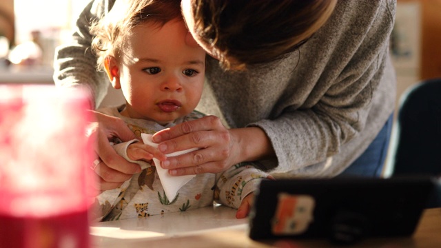 单身母亲给脏兮兮的男婴喂了捣碎的婴儿食物后给他清洗视频素材