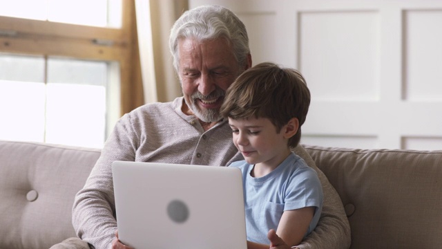 快乐的老爷爷和孙子使用笔记本电脑视频通话视频素材