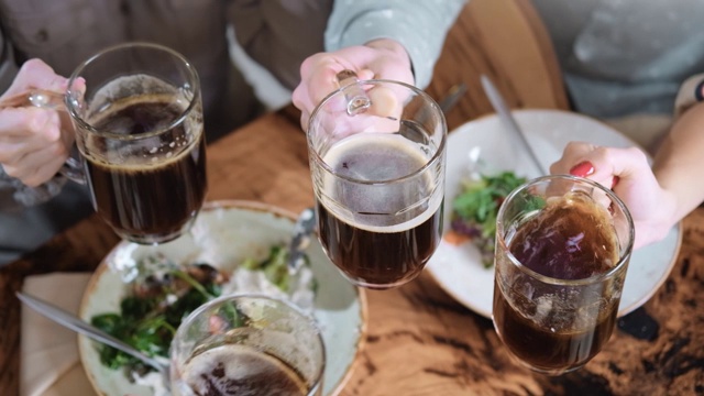 朋友们在桌上用慢动作喝着啤酒。近距离拍摄4k红色相机视频素材