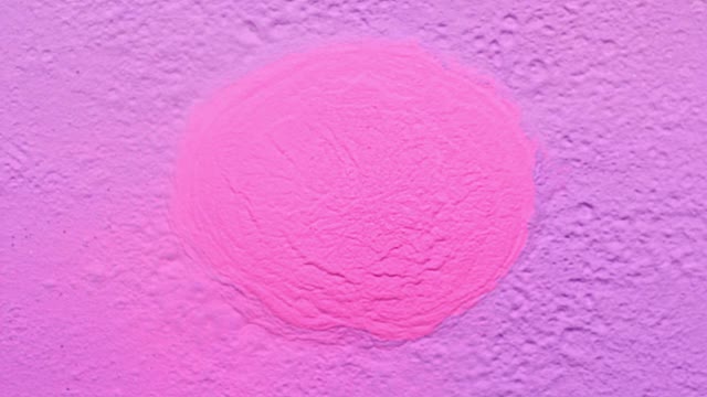 一个充满粉色粉末的表面，被紫色尘埃包围，向相机喷射，在近距离和超慢的动作中产生烟熏质感视频素材