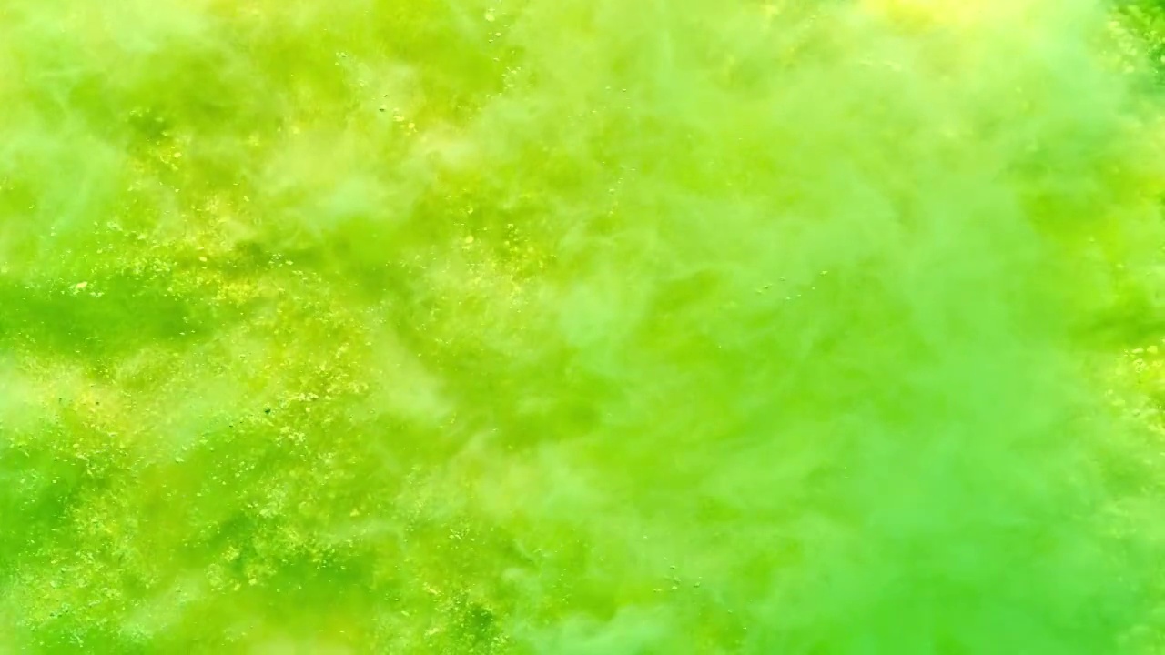 一个表面充满黄色和绿色的粉末喷向相机和跳跃的烟雾纹理近距离和超级慢的动作视频下载