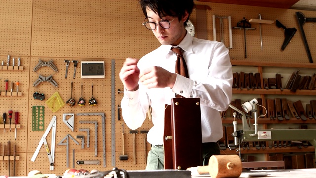 年轻的皮革工匠正在做一个包视频素材