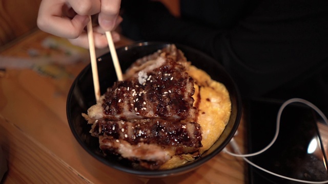 游客在日本餐厅吃炸猪肉饭的特写视频素材