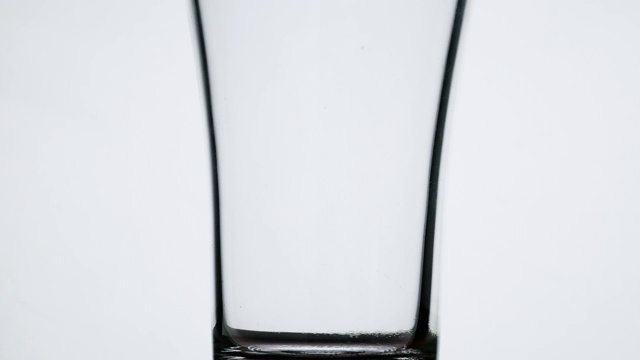 近浇果汁到玻璃，孤立在白色的背景。视频素材