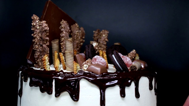 旋转美丽的蛋糕，装饰巧克力和糖果。视频下载