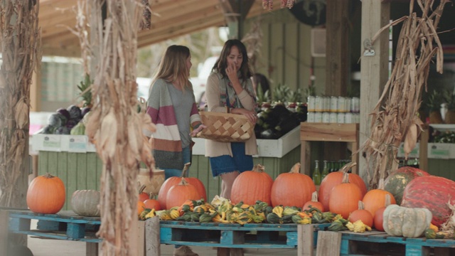 两个女人笑着一起在农贸市场购物视频素材