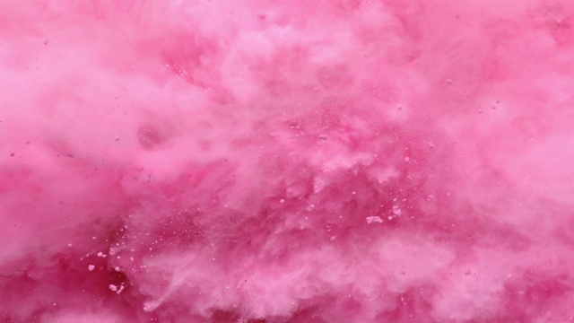 在近距离和超慢的动作中，一个充满粉色粉末的表面向摄像机喷射，跳跃的烟雾纹理视频素材