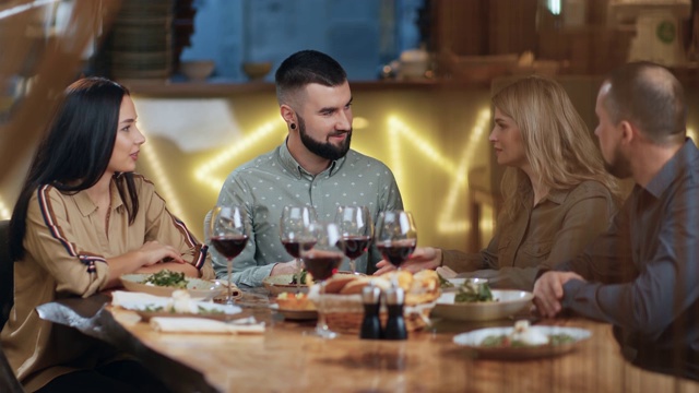 一群年轻男女在餐厅享受四人约会。由RED Raven 4k电影摄像机拍摄视频素材